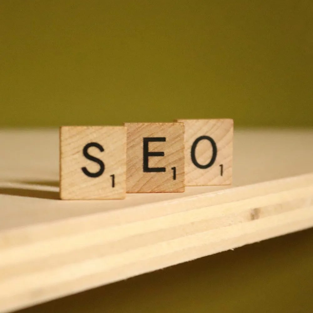 The words SEO on scrabble pieces on a wooden desk